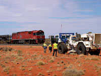 The seismic survey truck meets the Ghan along the Adelaide to Darwin railway. Copyright Geoscience Australia.