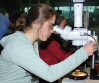 Student examines sample under microscope.
