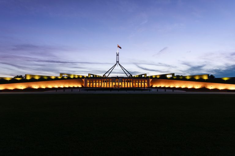 Australian Parliament House illuminated with dark blue sky