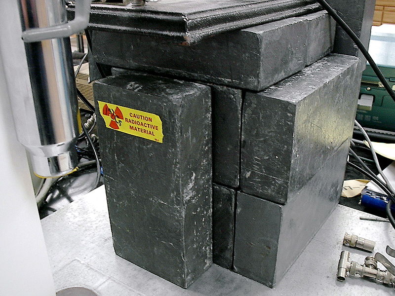 Rectangular, grey lead bricks stacked up to serve as a shield for a radioactive sample