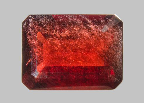 Shiny, red coloured almandine crystal cut into a rectangular shape