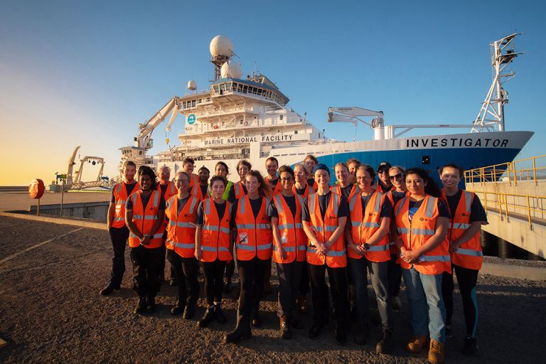 Geoscience Australia researchers standing in front of the CSIRO Marine National Facility research vessel RV Investigator before a marine science voyage