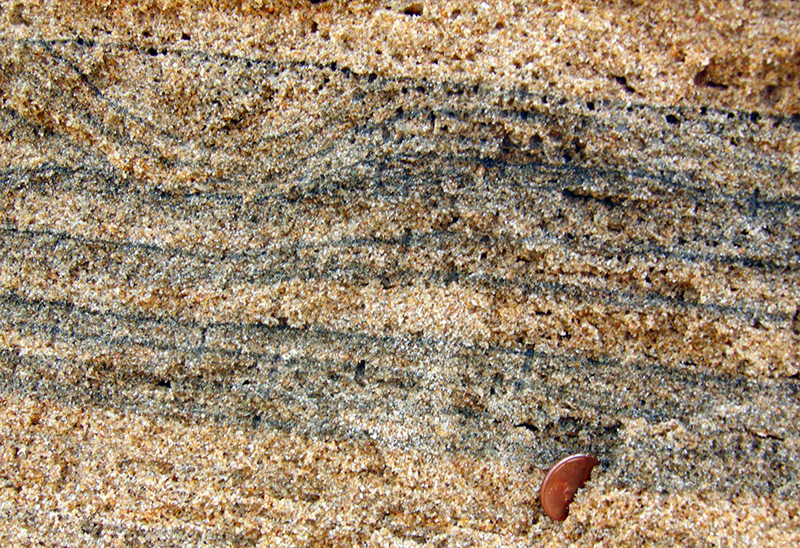 Fine dark mineral layers in white and yellow coloured beach sand