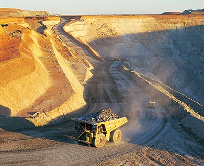 This photograph shows haul trucks hauling ore from an open cut nickel deposit in Western Australia.
