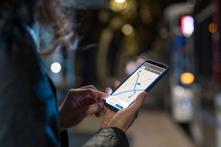 Woman using gps mapping app on phone at night