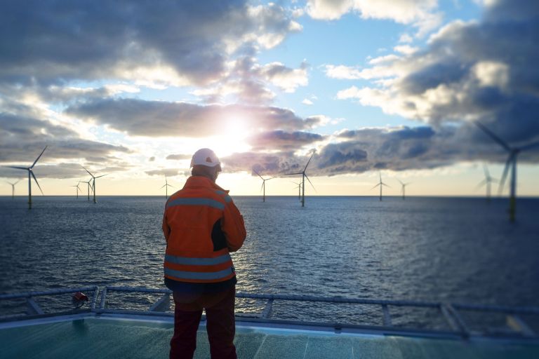 Engineer overlooking an offshore wind farm from a vessel during marine infrastructure operations