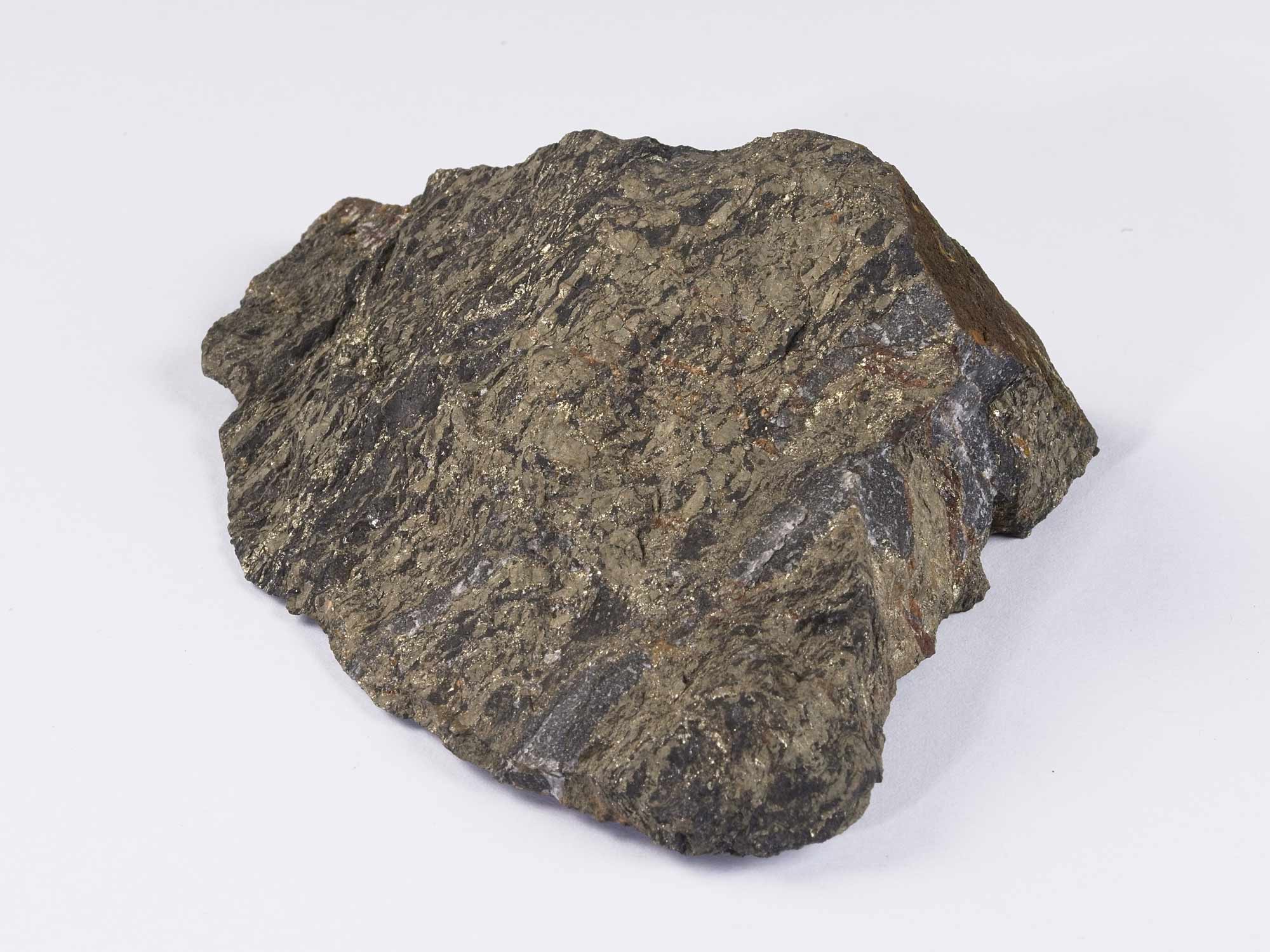 A dark brown rock sample with shiny gold-coloured flecks. This is a sample of Nickel Ore.