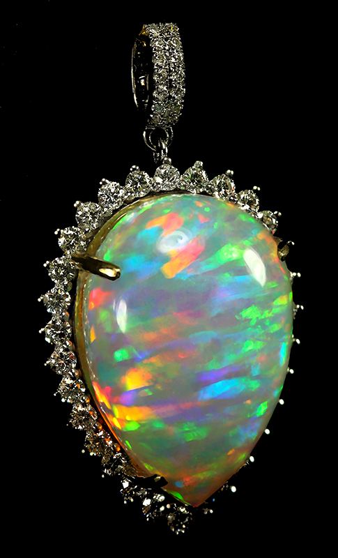 Round colourful opal mounted in an ornate metal pendant