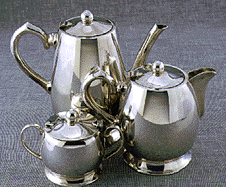 two ornate shiny silver pots and a shiny silver sugar container