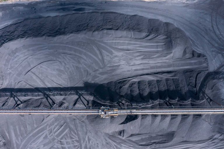 Drone aerial photograph of industrial machinery processing and moving crushed coal in a Colliery in regional Australia.