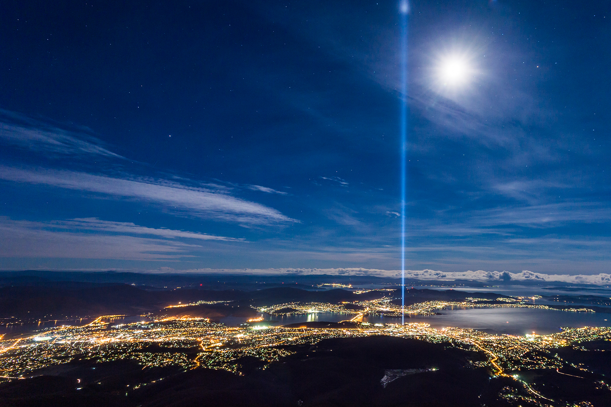 View of Hobart, Tasmania from Mt. Wellington with the Spectra light display. Spectra is a light and sound artwork installed in front of the Cenotaph that sits atop a small rise on the western shore of Hobart’s CBD.