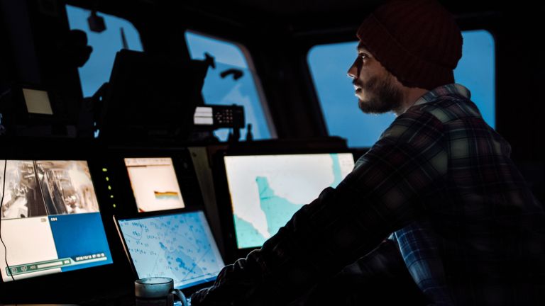 Survey vessel operator monitors navigation and hydrographic mapping systems from the ship's bridge during a marine survey