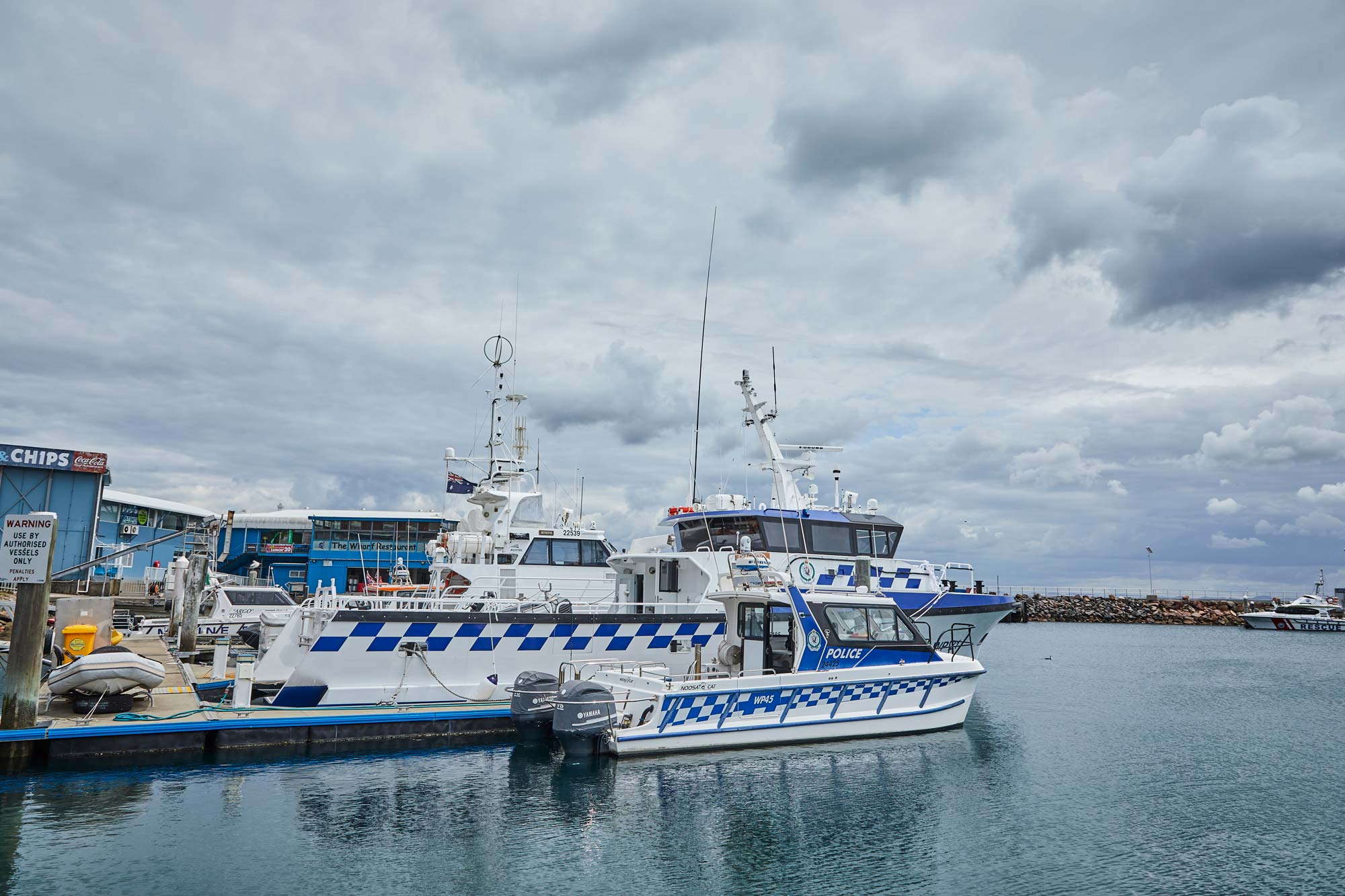 Australian Border Force and police patrol vessels moored at a marina, supporting maritime security, border protection and law enforcement
