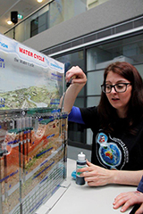 Geoscience Australia staff member explaining a plastic groundwater model.