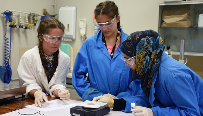 High-school students use scientific equipment to weigh mineral samples