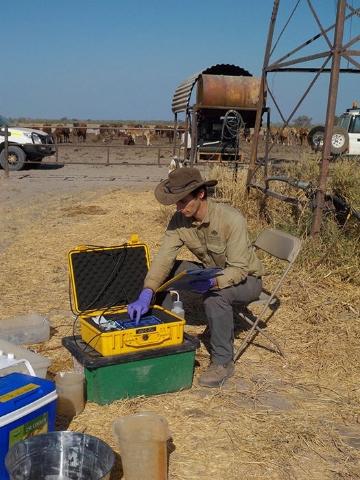 A man is siting with testing equipment in the Northern Territory.