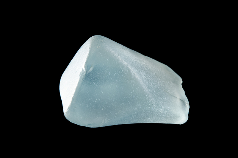 Transparent, pale blue, rounded topaz crystal.
