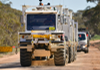 Large trucks driving on a dirt road