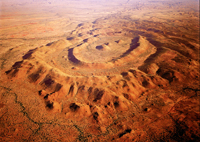 An aerial photo of the McIntosh Intrusion, Halls Creek Orogen, Western Australia. The McIntosh layered mafic intrusion which forms a prominent round geomorphic feature which looks similar to the cross-section of an onion. 