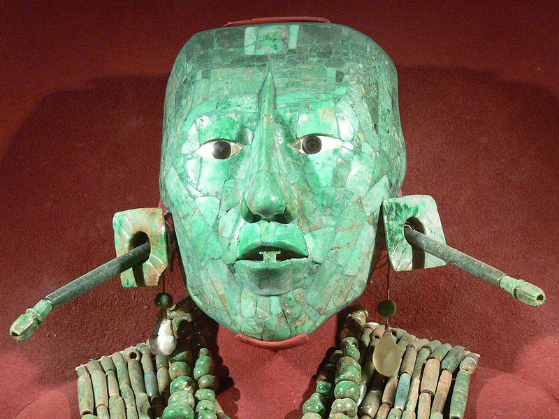 A green coloured mask of a man's face with large ears.