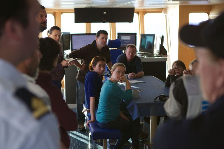 people having a meeting aboard a ship