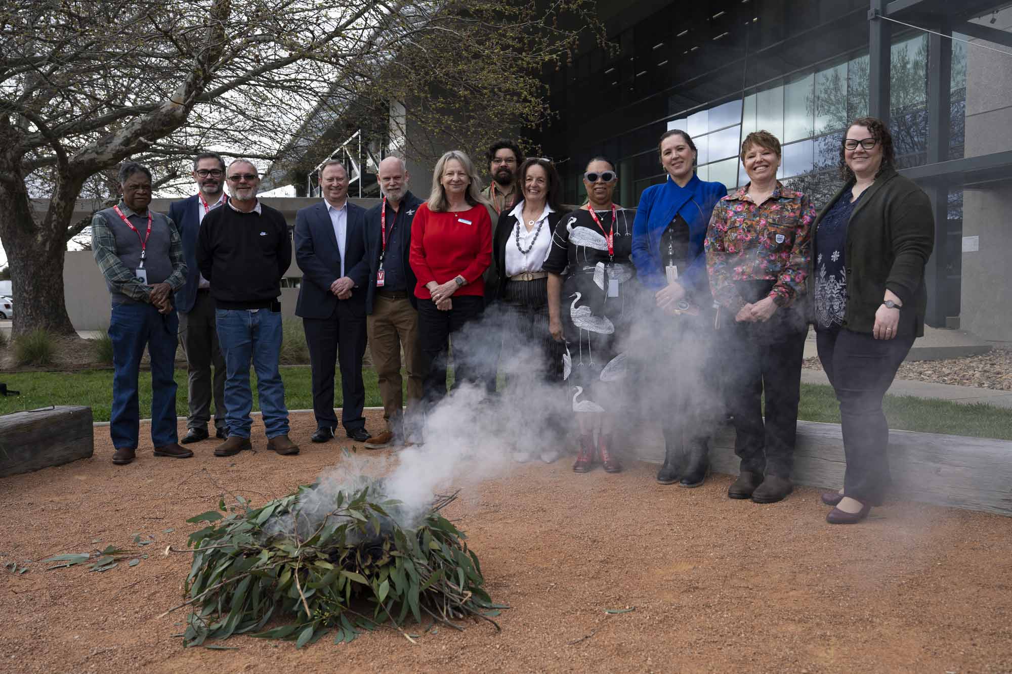 A group of people standing around a smoking fire