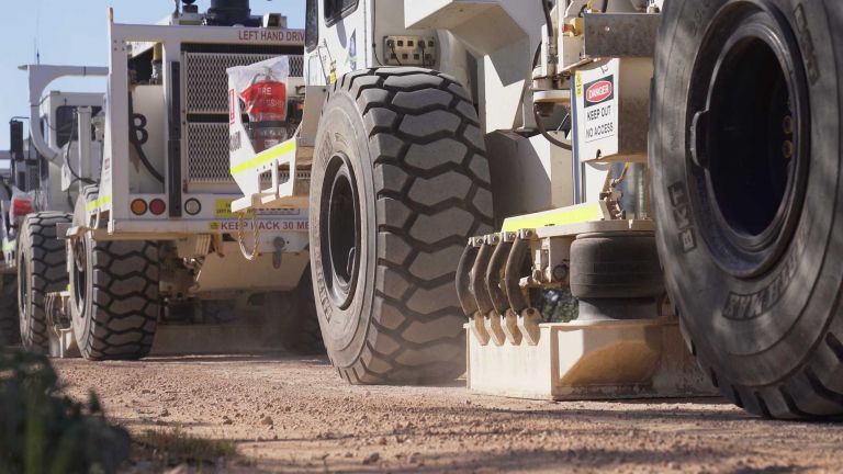 Vibroseis trucks at work with their vibrating plates down.