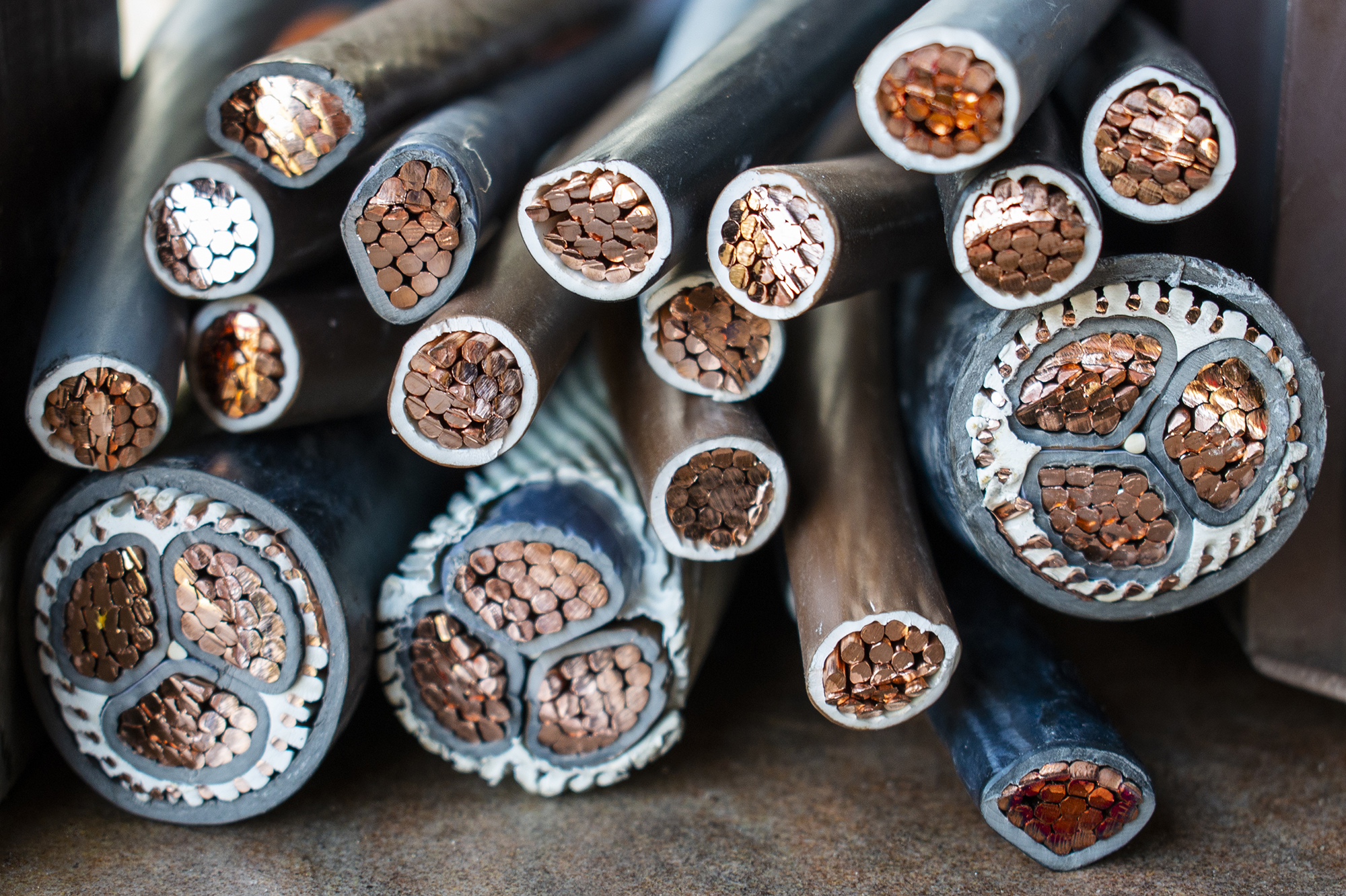 Macro photo of many copper wires twisted into rods and covered with plastic or gum isolation. Isolated copper wire endings cutted in half lying on a pile.