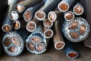 Macro photo of many copper wires twisted into rods and covered with plastic or gum isolation. Isolated copper wire endings cutted in half lying on a pile.