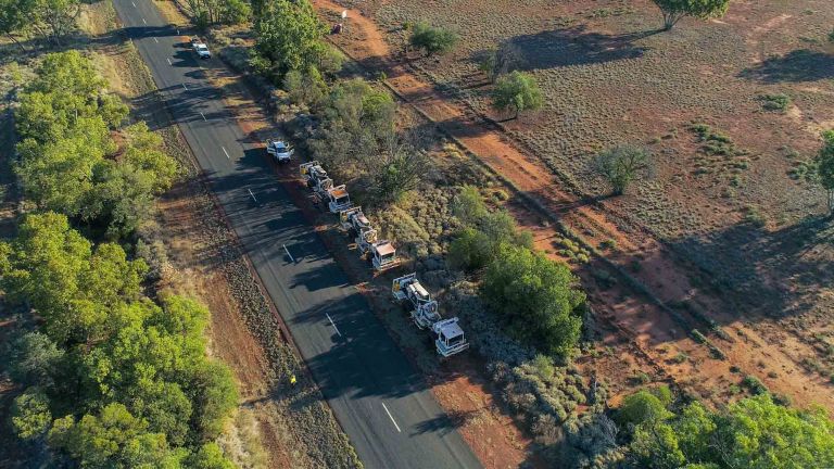 Trucks fitted with vibrating plates parked on the side of a road
