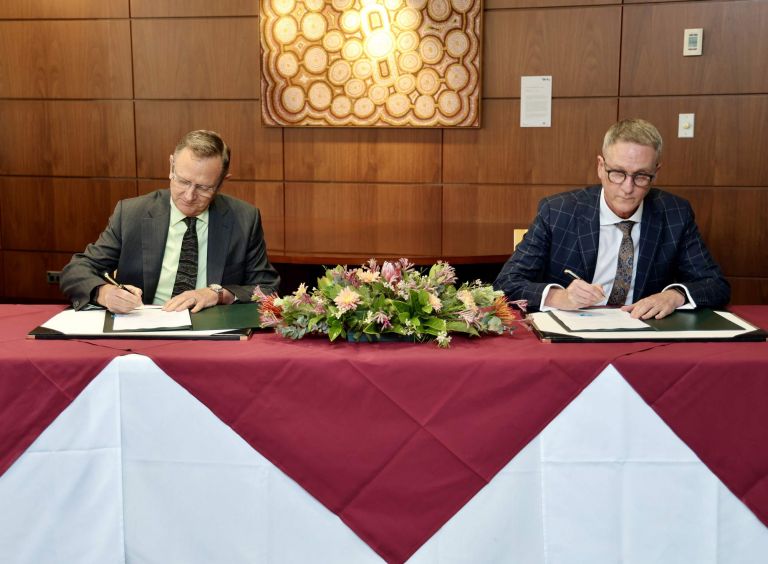 2 men signing documents