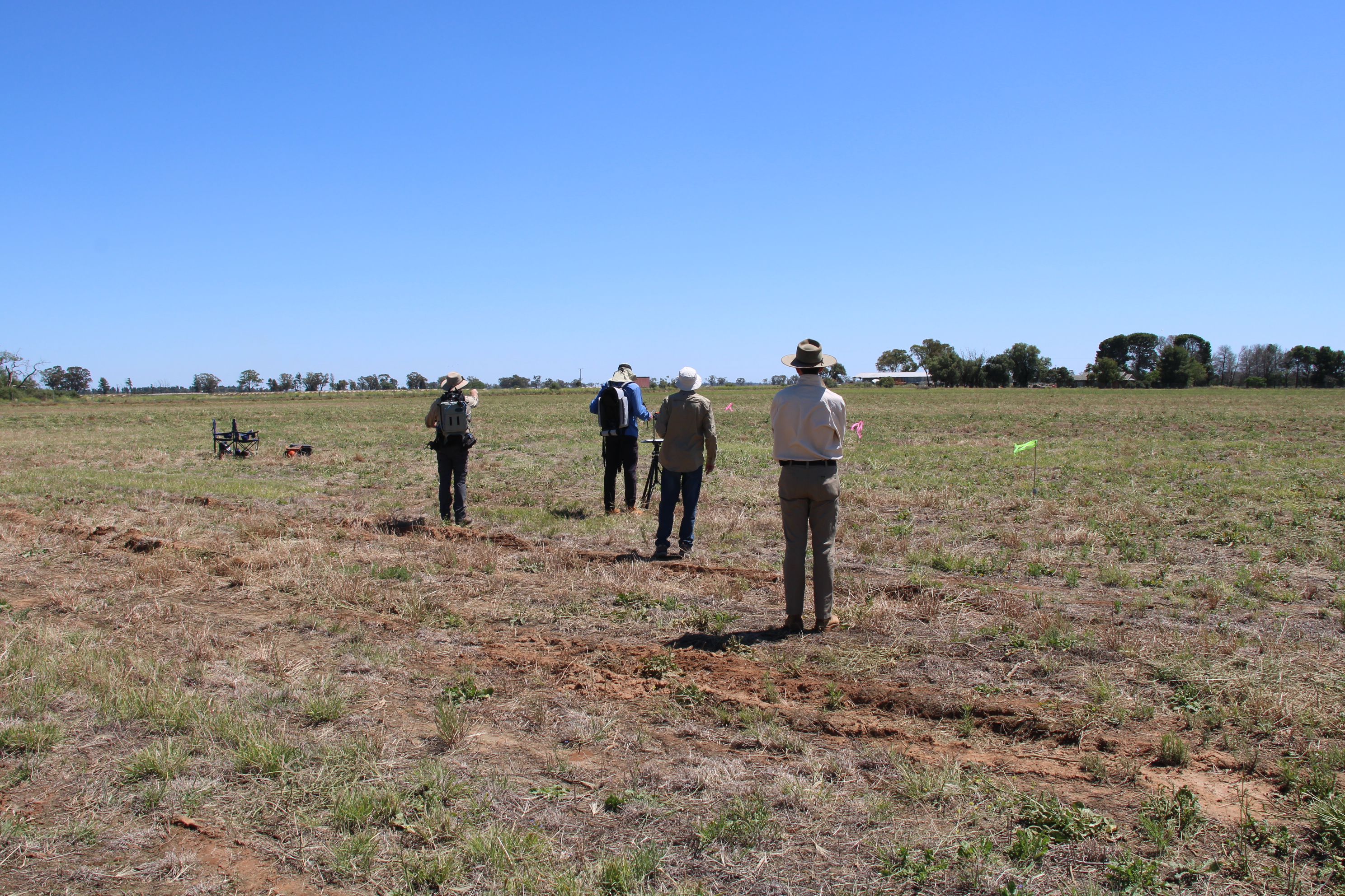Group of people standing ina field taking measeurements