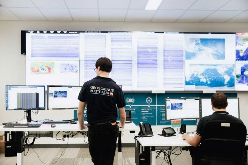 Geoscience Australia staff monitoring activity on big screens