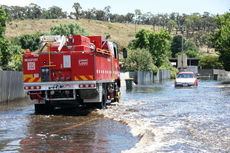 CFA library image of a car and fire truck approaching each other in high flood waters over a road