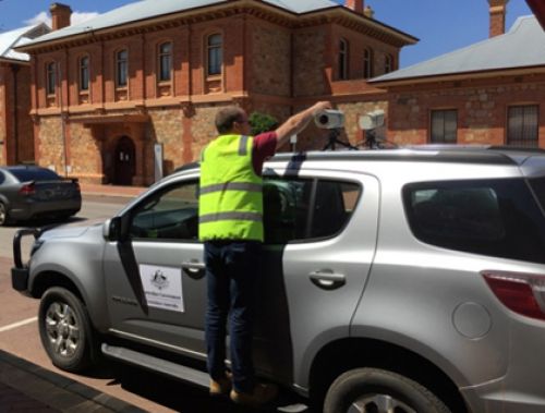 Man attaching a camera to the top of a car