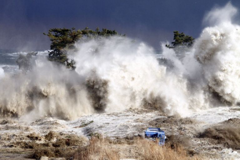 This picture taken on March 11, 2011 by Sadatsugu Tomizawa and released via Jiji Press on March 21, 2011 shows tsunami waves hitting the coast of Minamisoma in Fukushima prefecture. The number of people confirmed dead or listed as missing in Japan neared 22,000, 10 days after a massive earthquake and tsunami struck the country's northeast coast.  AFP PHOTO / JIJI PRESS (Photo credit should read SADATSUGU TOMIZAWA/AFP via Getty Images).