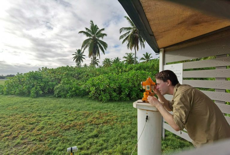 Project officer sites through a dumpy level in preparation for installing assets to the observatory network