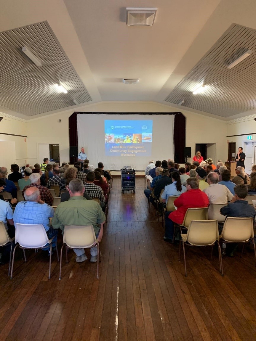 An earthquake awareness seminar with hazard scientist lecturing in front of an audience