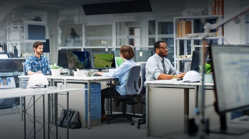 Bearded man and short-haired woman work at computers with satellite imagery