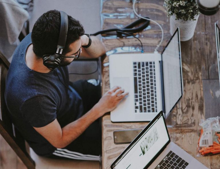 Man wearing headphones working on laptop
