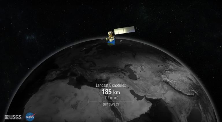 Video still showing abstract illustration of satellite over planet earth