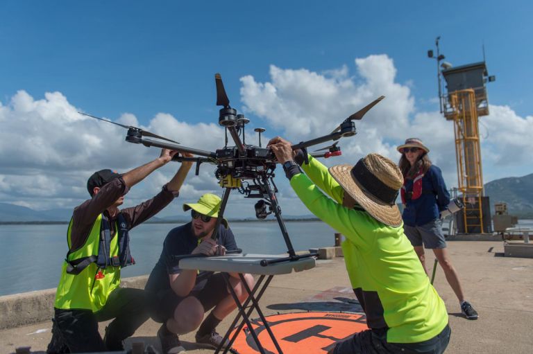 people launching a drone into flight