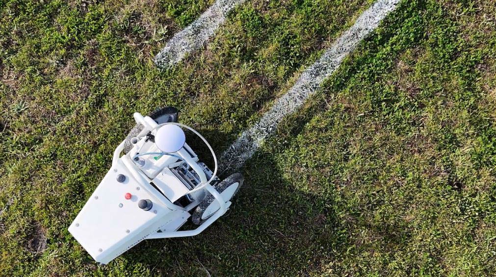 Robotic vehicle painting a sports field with white lines